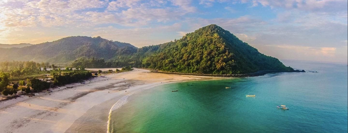 A breathtaking, cinematic wide shot of crystal-clear turquoise ocean waves crashing gently onto a pristine white sand beach.